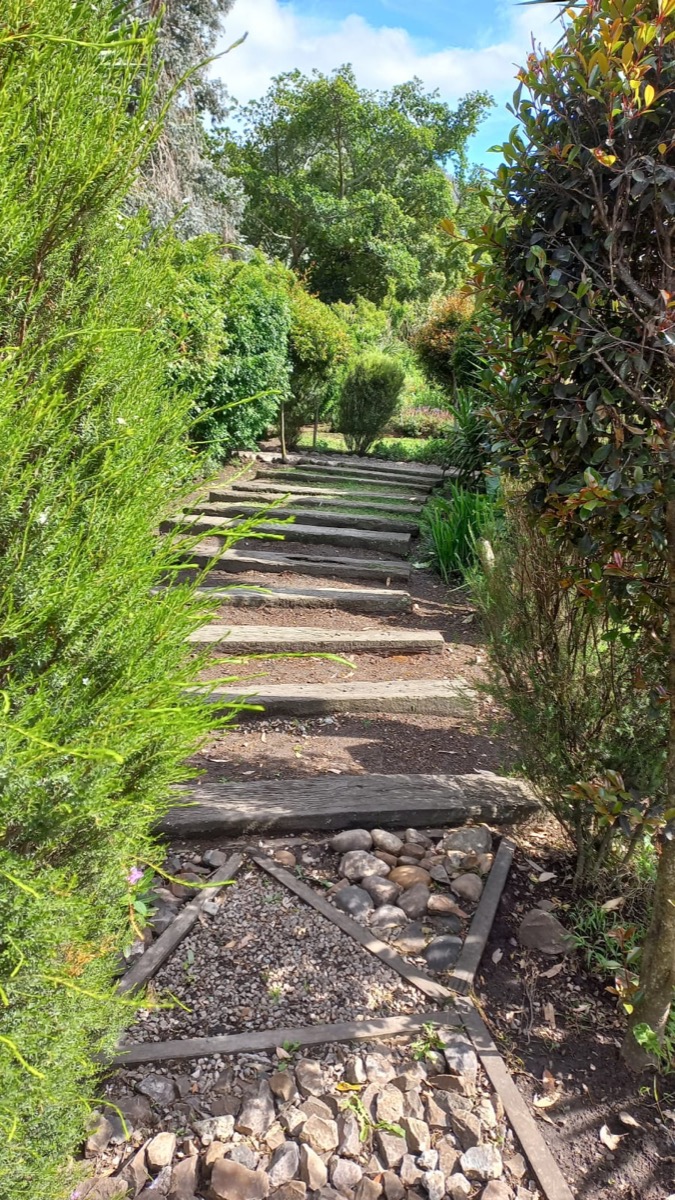 Stone pathway through lush gardens at Hope Station
